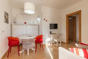 a living room with a table and red chairs at Agriturismo Residenza Gemma in Porto Cesareo
