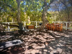 a deck with chairs and a table and a tree at Intimate Studio for Two at Hebron Estate in Piketberg