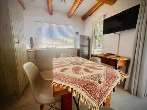 a kitchen with a table and chairs and a television at Intimate Studio for Two at Hebron Estate in Piketberg