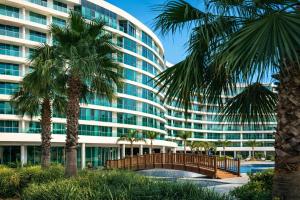 a large building with palm trees in front of it at Alodger Sirius Town Lara in Aksu