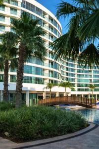 a large building with palm trees in front of it at Alodger Sirius Town Lara in Aksu