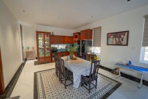 a dining room with a table and a kitchen at Kim Luông Homestay in Thôn An Hòa