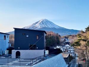 a snow covered mountain in the distance behind a building at Cocon富士 in Fujikawaguchiko