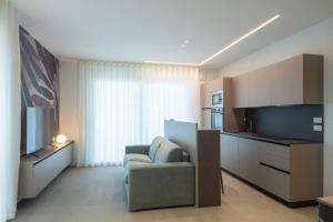 a living room with a couch and a chair in a room at A&G Elettra flat a pochi passi dal mare e Venezia in Cavallino-Treporti