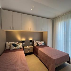 a bedroom with two beds and a cabinet at A&G Elettra flat a pochi passi dal mare e Venezia in Cavallino-Treporti