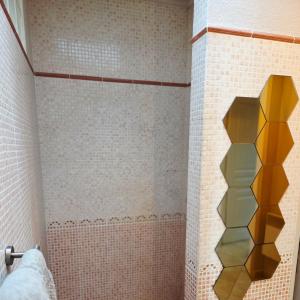 a bathroom with a shower with yellow tiles at Le HERON in Arles