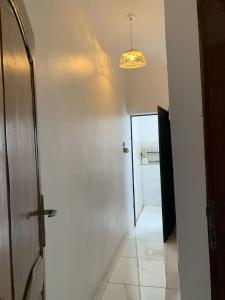 a room with a hallway with a door and a light at 2 chambres salon au calme in Porto-Novo