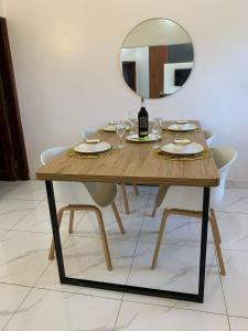 a wooden table with chairs and a mirror on it at 2 chambres salon au calme in Porto-Novo