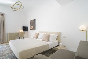 a white bedroom with a bed and a couch at Sopramonte Exclusive Rooms in Capri