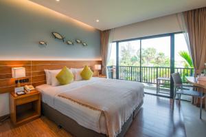 a bedroom with a large bed and a balcony at Fisherman's Resort Haad Chao Samran in Haad Chao Samran