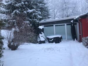 a snow covered shed with a table in front of it at Ferienhaus Am Eichenberg Haus 3 in Blankenburg