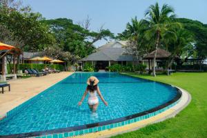 a woman in a hat walking into a swimming pool at Fisherman's Resort Haad Chao Samran in Haad Chao Samran +37 photos