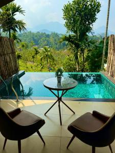 a patio with a table and chairs and a pool at Hayashi Resort in Meppādi