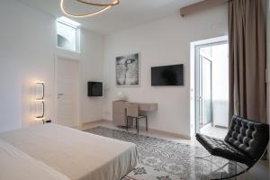 a white bedroom with a bed and a desk at Sopramonte Exclusive Rooms in Capri