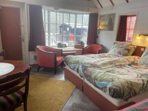 a bedroom with two beds and a table and chairs at Selatuinen in Appelscha