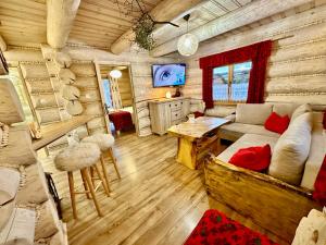 a living room with a couch and a tv in a log cabin at Sykowno chata in Szczyrk