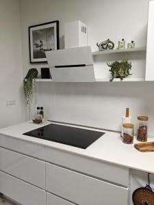 a white kitchen with a sink and shelves at Eksklusiv villalejlighed m/ have in Holme