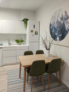 a kitchen with a wooden table and green chairs at Eksklusiv villalejlighed m/ have in Holme