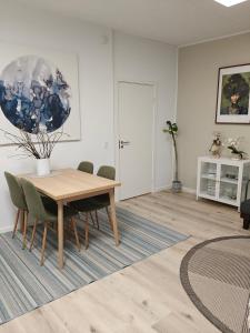 a dining room with a wooden table and chairs at Eksklusiv villalejlighed m/ have in Holme