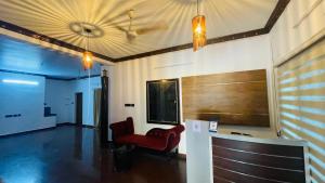 a lobby with a red chair and a bar at Jas Grand Homes in Cochin