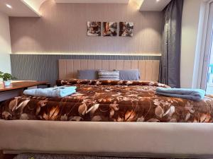 a bedroom with a large bed with a blanket at Luxury Couple Friendly Studio in Dehradun