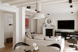 a living room with a couch and a tv at Villa Coste Simon's Town in Simonʼs Town