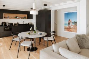 a kitchen and a living room with a table and chairs at Villa Coste Simon's Town in Simonʼs Town