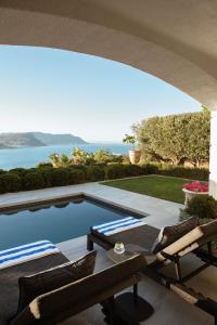 a swimming pool with two chairs and a table at Villa Coste Simon's Town in Simonʼs Town