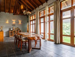 a dining room with a table and some windows at Elite Villa - By Purvish Hospitalities in Bangalore