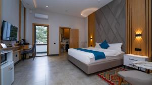 a hotel room with a bed and a kitchen and a living room at Parliament Palace Hotel in Khujand