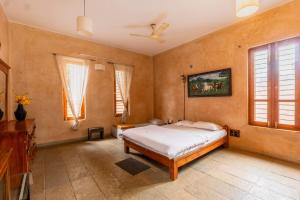 a bedroom with a bed and a ceiling fan at Elite Villa - By Purvish Hospitalities in Bangalore