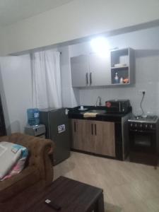 a kitchen with a couch and a sink and a stove at MSL Suites Apartment in Naivasha