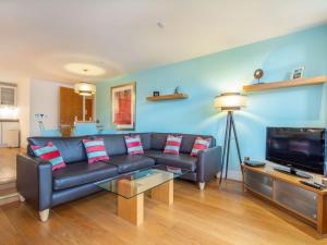 a living room with a couch and a tv at 208 By The Bridge Apartment in Inverness