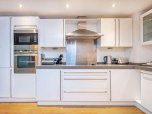 a kitchen with white cabinets and stainless steel appliances at 208 By The Bridge Apartment in Inverness