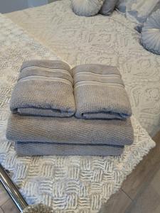 a pile of towels sitting on top of a bed at Bow Cottage in Bridport