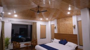 a bedroom with a bed and a ceiling fan at Ramjay Corbet Jungle Resort in Kotdwāra +22 photos