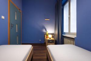 a room with two beds and a blue wall at WOW Hostel in Krakow