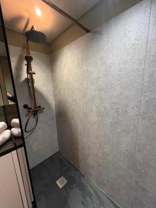 a shower in a bathroom with a gray wall at oh deer in Aalter