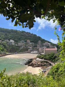 a beach with a town in the background at Horn Seaside Homestay in Nangan