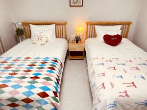two beds sitting next to each other in a bedroom at Mapo Panorama Stay in Seoul