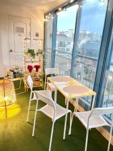 a room with tables and chairs on a balcony at Mapo Panorama Stay in Seoul