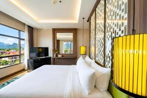a bedroom with a white bed and a large window at Amari Vang Vieng in Vang Vieng +57 photos