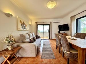 a living room with a couch and a table at Pêra Secret Garden 1 and Pool by Homing in Pêra