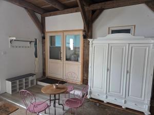 a room with pink chairs and a table and a cabinet at Ferienwohnung Noltenius 2 in Bülstedt