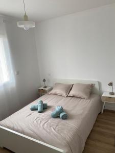 a white bed with two stuffed animals on it at Relax & work à Frespech 3 chambres 6 personnes in Frespech