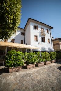 a building with plants in pots in front of it at Locanda Ai Archi Di Andreola Monica in Farra di Soligo