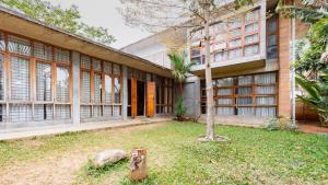 a building with a tree in front of it at Elite Villa - By Purvish Hospitalities in Bangalore