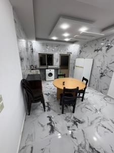 a kitchen with a table and chairs on a marble floor at Golden Stay in Jerash