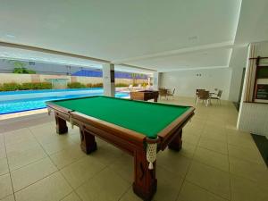a pool table in a room with a swimming pool at Nobile Imperial Flat in João Pessoa