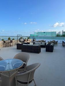 a patio with couches and tables and chairs at Nobile Imperial Flat in João Pessoa